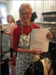  ?? PEG DEGRASSA – DIGITAL FIRST MEDIA ?? Tina Maguire, the eldest daughter of Steve and Florence Kosloski, has assumed the family matriarch position now that her parents are deceased. She hosts the family’s annual pierogi-making party each year at her home in Norwood. Here, Maguire holds up the time-honored family pierogi recipe from a book of family recipes that she and her sisters compiled.