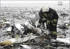  ??  ?? DEVASTATIO­N: Firemen sift through debris at the snowy crash site in Russia