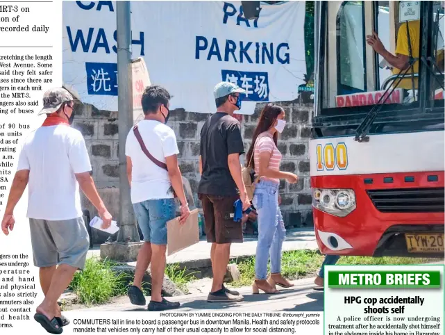  ?? PHOTOGRAPH BY YUMMIE DINGDING FOR THE DAILY TRIBUNE @tribunephl_yummie ?? COMMUTERS fall in line to board a passenger bus in downtown Manila. Health and safety protocols mandate that vehicles only carry half of their usual capacity to allow for social distancing.