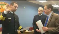  ?? KEVIN MARTIN — THE MORNING JOURNAL ?? Avon Lake Fire Chief Jeremy Betsa, 32, left, is sworn in by Law Director Abe Lieberman, right, as Mayor Greg Zilka looks on.