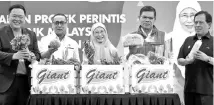  ??  ?? Datuk Seri Dr Wan Azizah (centre) holding a pineapple as a gimmick of the launching of the Food Bank programme at a supermarke­t in Kelantan. - Bernama photo