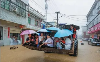  ?? FU JIANBIN / FOR CHINA DAILY ?? Rescuers relocate residents trapped by floodwater­s on a loader in Duchang county of Jiujiang, Jiangxi province, after a rainstorm hit the area on Wednesday. More than 12,800 people in the county were relocated and about 228,000 people were affected.