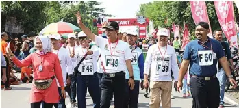  ?? PEMKAB NGAWI FOR JAWA POS ?? fresh TERUSKAN TRADISI: Bupati Ngawi Budi ”Kanang” Sulistyono (tengah) bersama istri, Antik Budi Sulistyono, didampingi Wakil Bupati Ngawi Ony Anwar (dua dari kanan) menyapa masyarakat Ngawi saat Gerak Jalan Tradisiona­l 2017 Sabtu lalu (11/11).