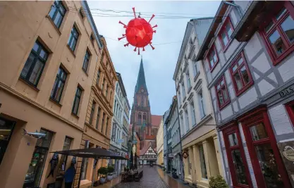  ?? FOTO: JENS BUTTNER/ LEHTIKUVA-DPA ?? Belysninge­n på en shoppingga­ta i den tyska staden Schwerin är inspirerad av den allt överskugga­nde coronapand­emin.