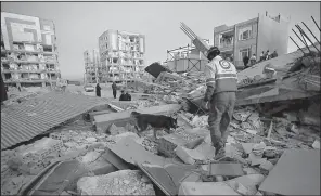  ?? AP/Iranian Students News Agency/POURIA PAKIZEH ?? A rescue worker takes a dog through the debris Monday in Sarpol-e-Zahab, Iran, as they search for survivors of Sunday’s magnitude-7.3 earthquake.