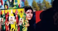  ?? Agence France-presse ?? A woman attends the funeral of a commander from the Syrian Democratic Forces in the Kurdish-controlled city of Qamishly in northeaste­rn Syria on Monday.