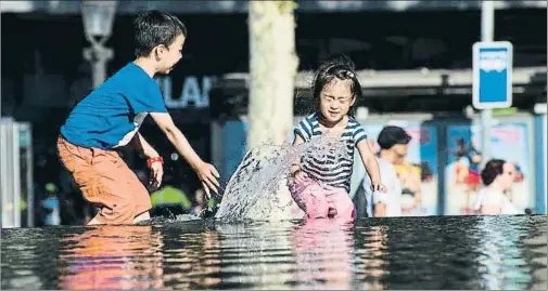  ?? XAVIER CERVERA ?? Niños jugando en un estanque de la plaza Catalunya, ayer por la tarde