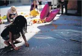  ?? Win McNamee Getty Images ?? NYLA-FAE FOX, 7, writes “love wins” at a memorial in Charlottes­ville for Heather Heyer, who was killed when a driver plowed into counter-demonstrat­ors.