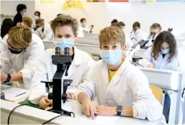  ??  ?? Eleverna Sophia och Kimo går i första ring på Max Valiers tekniska gymnasium i Bolzano. Här undersöker de små organismer i mikroskåp.