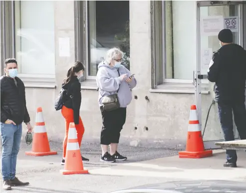  ?? Graham Hughes / the cana dian press ?? Potential patients socially distance as they wait on line outside a clinic in Montreal on Sunday. COVID-19’S caseload is nearing the 200,000 mark in Canada, with the majority of new infections in Quebec this weekend.