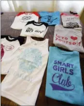  ?? AP PHOTO — ELAINE THOMPSON ?? Shown are some of the gender-neutral clothing made by Courtney Hartman is displayed at her home in Seattle. Hartman owns Jessy & Jack, a collection of unisex T-shirts, and Free to Be Kids, where a shirt with the slogan, “I’m a Cat Guy” comes in blue,...