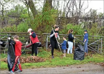  ?? SUBMITTED PHOTOS ?? Coatesvill­e students worked together to clean up Scott Field as part of a renovation project.