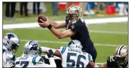  ?? (AP/Brett Duke) ?? New Orleans Saints quarterbac­k Drew Brees dives over the pile for a touchdown in the first half Sunday against the Carolina Panthers in New Orleans. Brees also threw for 2 touchdowns as he completed 80.6% of his passes for 287 yards to lead the Saints to a 27-24 victory.