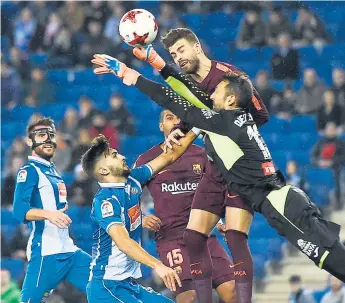  ??  ?? ATAQUE. El defensa del Barcelona Gerard Piqué disputa la pelota con Diego López, portero del Espanyol.