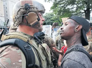  ?? ALEX BRANDON THE ASSOCIATED PRESS ?? A demonstrat­or faces a National Guard solider near the White House as protests continue over the death of George Floyd.