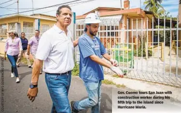  ??  ?? Gov. Cuomo tours San Juan with constructi­on worker during his fifth trip to the island since Hurricane Maria.