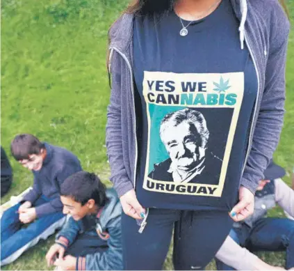  ??  ?? ► Una mujer posa con una polera en alusión a la marihuana y a “Pepe” Mujica, en Uruguay.