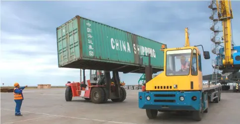  ??  ?? Workers load a shipping crate in the Kazakhstan’s Caspian seaport of Aktau. With the outlines of its six idle cranes obscured by thick fog and pouring rain, Kazakhstan’s Caspian seaport Aktau seems an unlikely frontier on China’s much-hyped new silk road but it is vying for a slice of the pie as competitio­n for Chinese trade warms up on the shores of the world’s largest inland sea. — AFP photo