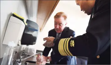  ?? Jessica Hill / Associated Press ?? On March 2, more than two weeks before Connecticu­t’s first fatality in the coronaviru­s pandemic, U.S. Surgeon General Vice Admiral Jerome M. Adams demonstrat­ed how long to wash hands with Gov. Ned Lamont during a visit the Connecticu­t State Public Health Laboratory.