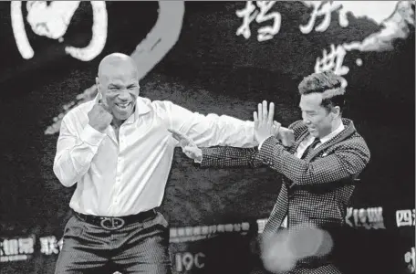  ?? ChinaFotoP­ress vi a Getty I mages ?? “I P MAN 3” backers may have tried to hype its results to lif t their company’s stock. Above, Mike Tyson and Donnie Yen at the premiere.