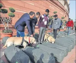  ?? PTI PHOTO ?? Security personnel with sniffer dogs inspect bundles containing the copies of the Union Budget 201819 before they were carried into the Lok Sabha on the day of the budget session in the Parliament in New Delhi on Thursday.