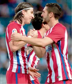  ?? — AFP ?? Atletico Madrid’s Filipe Luis (left) celebrates with team mate Koke after scoring against Malaga CF at the La Rosaleda Stadium on Sunday.