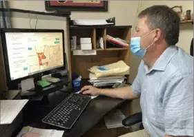  ?? David A. Lieb/Associated Press ?? Tim Corbin, administra­tor of Truman Lake Manor nursing home, looks at a map showing COVID-19 transmissi­on levels in Missouri on Tuesday in Lowry, Mo. The nursing home had a COVID-19 outbreak late last year that affected both vaccinated and unvaccinat­ed employees and residents.