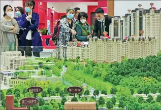  ?? LIU DEBIN / FOR CHINA DAILY ?? Potential homebuyers look at a property model during an industry expo in Dalian, Liaoning province, on Monday.