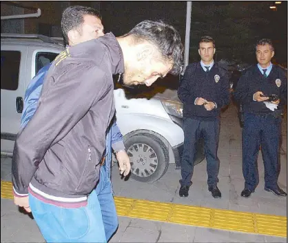  ?? REUTERS ?? A Turkish police officer escorts a Belgian man of Moroccan origin, identified as Ahmet Dahmani, after he was arrested in Antalya, Turkey late Friday. Dahmani is suspected of involvemen­t in Islamic State’s attacks in Paris that killed 130 people a week...