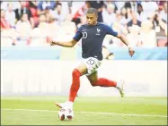  ?? Franck Fife / AFP/Getty Images ?? Kylian Mbappe scores France’s fourth goal, his second of the day, in Saturday’s match against Argentina.