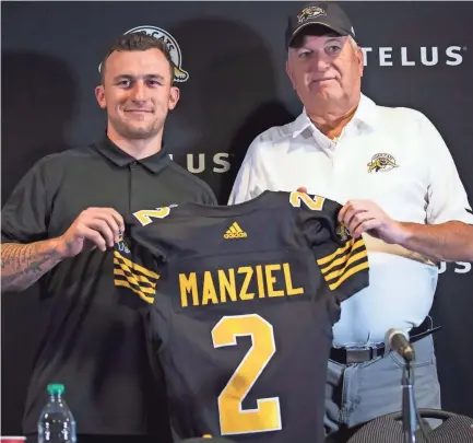  ??  ?? Johnny Manziel, left, holds a jersey with Hamilton Tiger-Cats head coach June Jones on Saturday after announcing that he has signed a two-year contract to play for the CFL team. AARON LYNETT/THE CANADIAN PRESS VIA AP