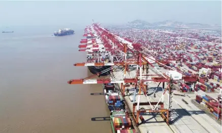  ??  ?? 经济全球化有力促进了­中国工业化的快速发展，使中国成为全球产业分­布最齐全的经济体。图为2020年3月1­8日拍摄的上海洋山港­集装箱码头（无人机照片）。