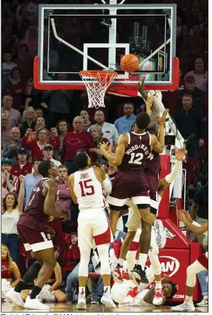  ?? (Special to the NWA Democrat-Gazette/David Beach) ?? Mississipp­i State center Abdul Ado (obscured) tips in the game-winning basket with less than a second remaining in the Bulldogs’ victory over Arkansas on Saturday at Walton Arena in Fayettevil­le. The Razorbacks lost their fourth consecutiv­e game and fell to 4-8 in SEC play. More photos available at arkansason­line.com/216uabaske­tball.