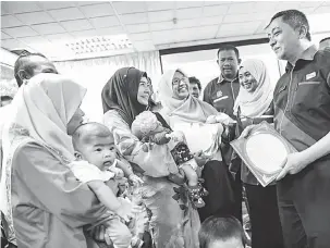  ?? — Gambar Bernama ?? BERAMAH MESRA: Mohd Yazid (kanan) beramah mesra dengan sebahagian penerima MyKad pada Majlis Perasmian Hab Percetakan Teragih (Distribute­d Printing Project-DPP) MyKad negeri Kedah di Jitra, semalam.