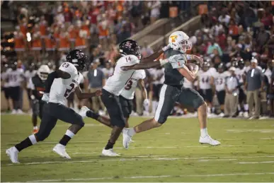  ?? Staff photo by Evan Lewis ?? Texas High quarterbac­k Coltin Clack finds room to run as Liberty-Eylau safeties Kentrell Chatmon and Dominique Williams try to get a hand on him during Friday night's game at Tiger Stadium. THS got its first win of the season, beating the Leopards 37-23.