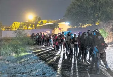  ?? JOHN MOORE / Getty Images ?? Central American families wait to be processed by U.S. Border Patrol agents after crossing the U.s.-mexico border early Saturday morning in Roma, Texas.