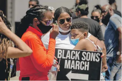  ?? PAT NABONG/SUN-TIMES ?? Erica Hentz, 38, hugs her son, Anthony Toliver, 11, during a protest on the Far South Side on Sunday.