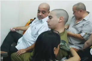  ?? (Yonah Jeremy Bob) ?? ELOR AZARIA and his father Charlie (left) appear in the Jaffa Military Court yesterday.