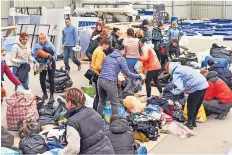  ?? ?? Female Ukrainian refugees take what they need from the Polish warehouse