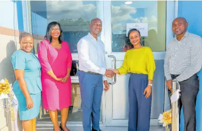  ?? CONTRIBUTE­D ?? Kingston Wharves Limited (KWL) CEO Mark Williams (third left) and Medical Associates Vice-President for Strategic Growth and Operations Toni Cooke (second right) seal the deal following the ribbon-cutting ceremony to officially open KWL’s Medical Centre at its Kingport location recently. Others joining in the moment (from left) are Medical Associates Director of Nursing Operations Sharmen Edwards, KWL’s Human Resources and Administra­tion Manager Denise Walcott-Samuels, and Roan Campbell, KWL’s safety, health and environmen­t manager.