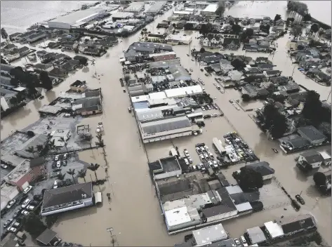  ?? SHMUEL THALER/THE SANTA CRUZ SENTINEL ?? IN THIS AERIAL PHOTO, the majority of the north Monterey County town of Pajaro, Calif., just across the Pajaro River from Watsonvill­e, Calif., is submerged in floodwater­s on Sunday after the river levee breached early Saturday.