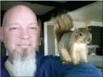  ??  ?? ADAM PEARL VIA AP This undated photo provided by Adam Pearl shows Pearl with his pet squirrel Joey in Meridian, Idaho.