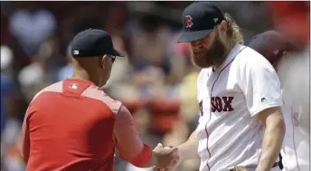  ??  ?? Boston Red Sox’s Andrew Cashner (right) hands the ball to manager Alex Cora (left) as he is retired from a baseball game in the second inning against the Los Angeles Angels at Fenway Park, on Sunday in Boston.
AP PHOTO/STEVEN SENNE