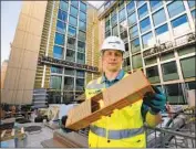  ??  ?? NATE JENKINS, an executive with Mortenson, holds a model of a module used in constructi­on.