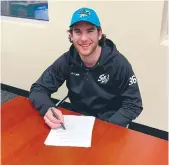  ??  ?? Former Moose Jaw Warriors goaltender Zach Sawchenko signs his NHL contract with the San Jose Sharks.