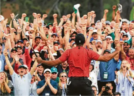  ?? David Cannon / Getty Images ?? Masters champion Tiger Woods soaks it all in after sinking his final putt to the thunderous cheers of the gallery around the 18th green.