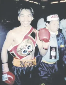  ?? PHOTOGRAPH BY NICK GIONGCO FOR THE DAILY TRIBUNE ?? A JUBILANT Manny Pacquiao (left) strikes a pose after winning the IBF super-bantamweig­ht crown in his US debut in June 2001. The late Ben Delgado assisted Freddie Roach in the corner.