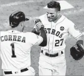  ?? BOB LEVEY/GETTY ?? Jose Altuve (27) gets a handshake from Carlos Correa after homering off David Robertson in the eighth inning.