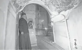  ??  ?? A Greek priest examines restoratio­n work inside the renovated Edicule.