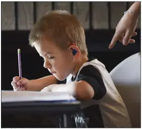  ?? (NWA Democrat-Gazette/Charlie Kaijo) ?? Colton Andrews, 6, a first-grader with a learning disability caused by a brain injury, does school work at his home in Greenwood on Nov. 20. Colton and his sister, Christina, 13, have been attending school in person this fall after struggling with online classes in the spring, but Greenwood has shifted to online learning through the end of November. More photos at arkansason­line.com/1129viruse­d/.